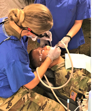 Army dentist performs dental work on a Soldier during a field training exercise held recently at Baumholder, Germany. (U.S. Army photo by Kirk Frady)